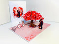 Couple in Love under a Hot Pink Love Heart Cherry Blossom Tree 3D POP UP GREETING CARD - Created by Origami Pop Cards Australian Design & Handmade 3D Pop Up Magical Paper Cards, Handmade Pop Up Cards Celebrate Love Anniversary Heart Fell and Romantic
